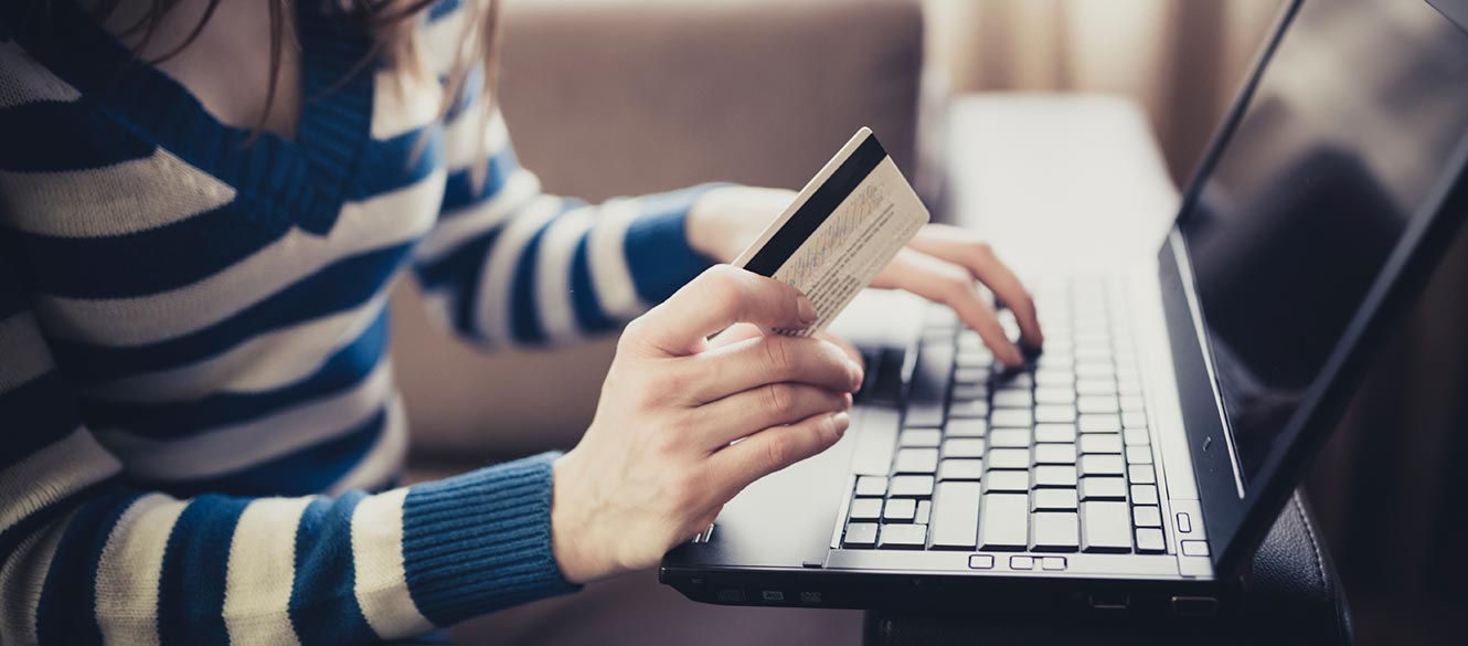 Lady with a debit card on a laptop