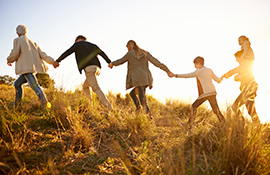 Family holding hands climbing a hill