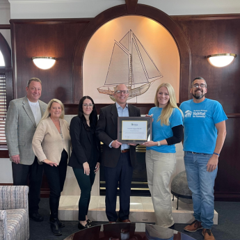 team members with habitat for humanity staff and award